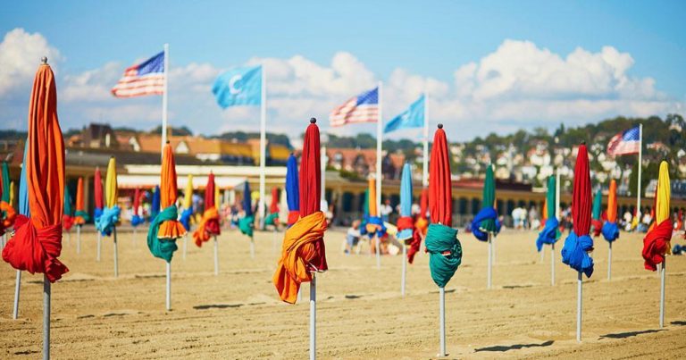 Deauville / bunte Sonnenschirme am Strand - bei Reisemagazin Plus